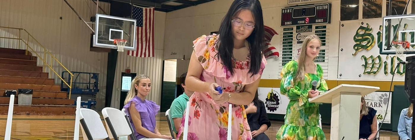 Image of Honor Society member lighting a candle