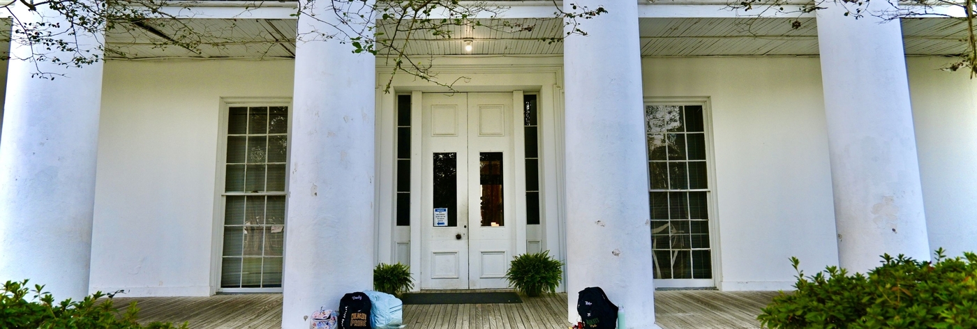 Image of front porch with student backpacks near the steps