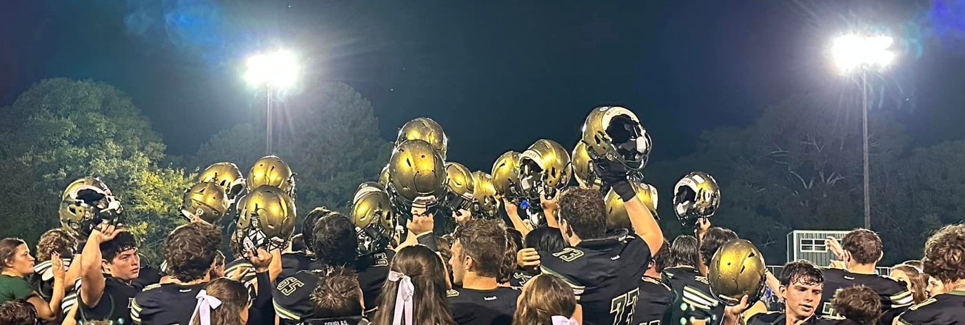 Image of football team with helmets in the air